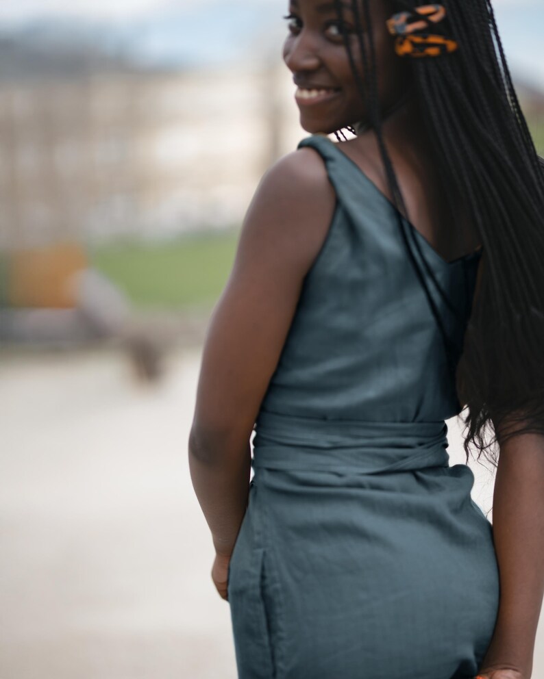 Ready to ship in 1 day, this soft green linen midi dress features a flattering fit with a deep V-back, adjustable twisted straps, and a wide tie belt that enhances the waistline. The lightweight linen flows naturally with movement, making it an ideal choice for summer vacations, city walks, or outdoor gatherings. Elegant and comfortable, it's a timeless look for women who value natural style and ease.