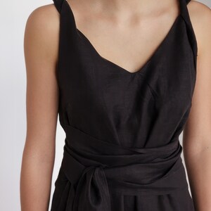 Ready to ship in 1 day, close-up of black linen midi dress with twisted shoulder straps, soft V-neckline, and wide wrap belt. Lightweight and breathable fabric, ideal for summer events, vacation evenings, or minimalist everyday wear.