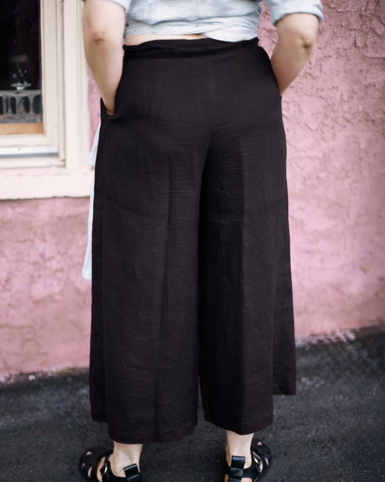 Ready to ship in 24 hours from USA — back view of black linen culottes with wide leg silhouette and elastic waistline for flexible fit. Lightweight and breathable, perfect for summer and plus size bodies. Designed for effortless everyday wear, travel, and modern minimalist style. Soft natural fabric, no back pockets for a clean, flattering look.