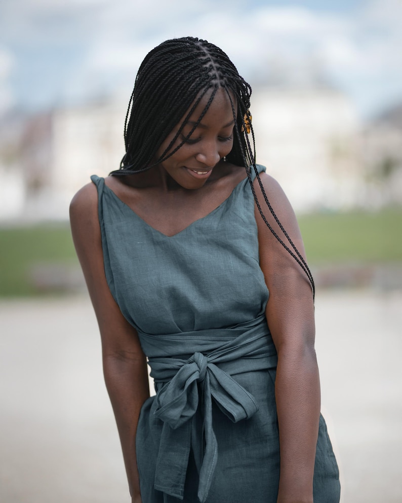 Ready to ship in 1 day, this soft green linen dress features twisted straps, a deep V-neckline, and a long belt that wraps at the waist for a flattering silhouette. Made from breathable organic linen, it's perfect for vacations, summer getaways, and relaxed city strolls. A feminine, timeless piece designed for women who love comfort and effortless style. Ideal as a thoughtful gift or a go-to summer outfit.