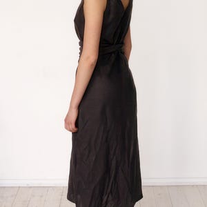 Ready to ship in 1 day, back view of a black linen midi dress with wide wrap sash and deep V-cut on the back. Elegant and lightweight, perfect for warm-weather occasions, city strolls, or vacation evenings. Feminine silhouette highlights the waist and flows naturally.