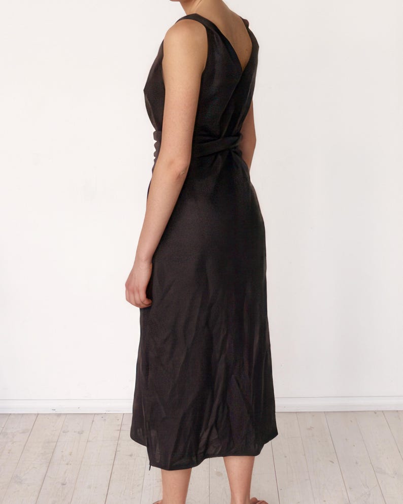 Ready to ship in 1 day, back view of a black linen midi dress with wide wrap sash and deep V-cut on the back. Elegant and lightweight, perfect for warm-weather occasions, city strolls, or vacation evenings. Feminine silhouette highlights the waist and flows naturally.
