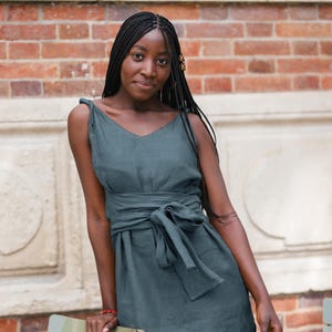 Ready to ship in 1 day, this soft green linen dress with belt is a comfortable and flattering choice for warm days. Featuring a deep V-neck, twisted straps, side splits, and a long tie sash, it gracefully defines the waist. Made from breathable organic linen, it’s perfect for vacations, summer travel, casual weekends, or brunch with friends. A timeless, elegant piece and a lovely gift for her.