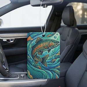 Puede incluir: Un ambientador de coche rectangular colgado del espejo retrovisor, con una vibrante ilustración estilizada de un pez nadando a través de aguas azules y verdes arremolinadas con patrones geométricos y burbujas en todo el diseño.