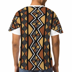 Puede incluir: Una camiseta blanca con un patr&oacute;n geom&eacute;trico marr&oacute;n, negro y blanco. El patr&oacute;n est&aacute; inspirado en el arte tribal africano.
