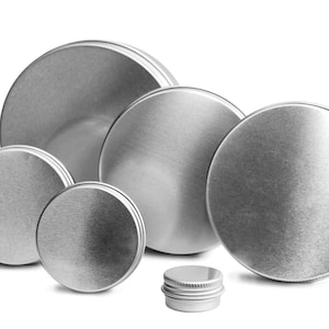 Op de afbeelding: Een set van zes ronde zilveren metalen blikken in verschillende maten. De blikken zijn in een verspringende opstelling geplaatst, met de grootste blik bovenaan en de kleinste blik onderaan. De blikken zijn allemaal gemaakt van glad, glanzend metaal.