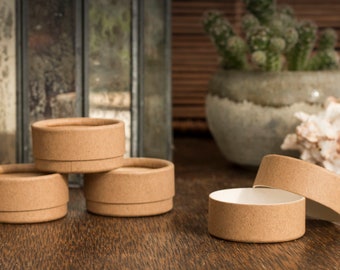 May include: Four brown cardboard containers with lids, three are closed and one is open, sitting on a wooden surface.