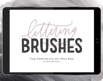 May include: A black iPad Pro with a white screen displaying the text "lettering brushes" in a pink cursive font and "for procreate on iPad Pro by makemedia.co" in a smaller black font.