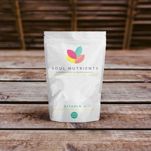 Puede incluir: Bolsa blanca con un logotipo de hoja colorido y el texto "SOUL NUTRIENTS SUPERFOODS & SUPPLEMENTS". La bolsa contiene suplementos de vitamina C con 1000 mg por porci&oacute;n.