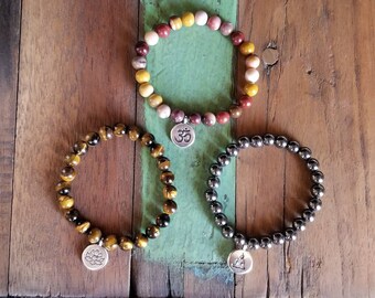 Elastische Zen stenen armbanden met Boeddha, aum of lotus charme.