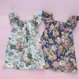 K&ouml;nnte beinhalten: Zwei Kleider mit Blumenmuster, off-shoulder-Ausschnitt und R&uuml;schen&auml;rmeln. Das Kleid links ist hellgr&uuml;n mit einem rosa-wei&szlig;en Blumenmuster. Das Kleid rechts ist dunkelblau mit einem rosa-wei&szlig;en Blumenmuster.