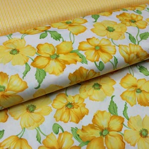 May include: Fabric with a floral pattern of yellow flowers and green leaves on a white background. A second fabric with a yellow gingham pattern is visible in the background.