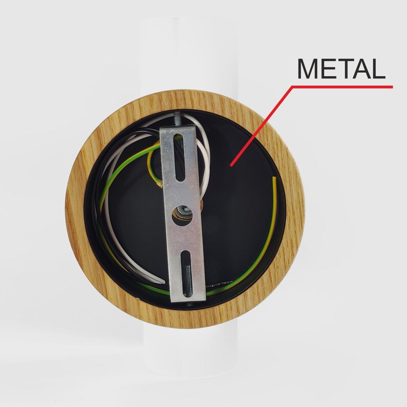 Puede incluir: Primer plano de una l&aacute;mpara de madera con interior negro. La l&aacute;mpara tiene un soporte met&aacute;lico y varios cables de colores. La palabra "METAL" est&aacute; escrita en texto negro con una flecha roja que apunta al soporte met&aacute;lico.