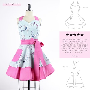 May include: A pink and blue apron with a mermaid print and a pink polka dot ruffle. The apron has a large pocket on the front and a tie at the back. The apron is on a white background.