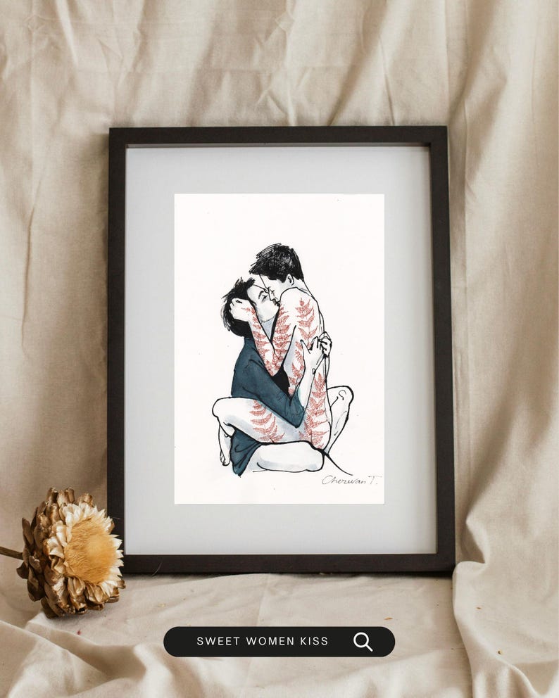 May include: A framed art print featuring a black ink illustration of two figures embracing and kissing. One figure wears a dark blue shirt, while the other has reddish-brown fern-like patterns on their skin. The print is signed Cherwan T.