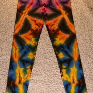 May include: Tie-dye leggings in a vibrant array of colors. The leggings feature a symmetrical pattern with hues of red, orange, yellow, blue, and purple. The design creates a starburst effect, perfect for casual wear.