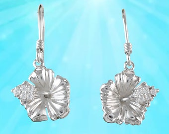 May include: A pair of silver dangle earrings featuring a detailed hibiscus flower design with clear cubic zirconia stones.