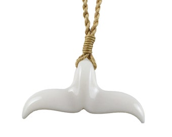 May include: White ceramic whale tail pendant necklace with a brown rope cord.