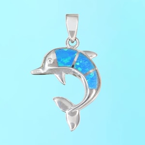 May include: A silver dolphin pendant with blue opal inlay. The dolphin is jumping out of the water with its tail up.