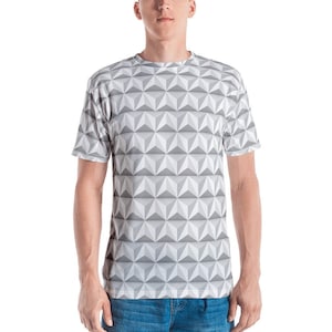 May include: A short-sleeved t-shirt with a geometric pattern. The design features a repeating pattern of gray and white three-dimensional shapes. The shirt is made of a soft material and is suitable for casual wear.