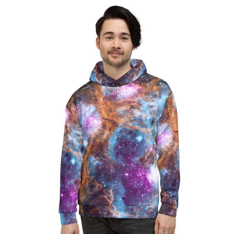 May include: A hooded sweatshirt featuring a vibrant galaxy design in shades of blue, purple, and orange. The pullover has a front pocket and a drawstring hood. The all-over print creates a cosmic aesthetic.
