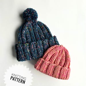 May include: Two knitted beanies. One is teal with a pom-pom and flecks of color, the other is pink and orange. The beanies are made with a ribbed knit pattern. The text "KNITTING PATTERN" is in a white starburst.