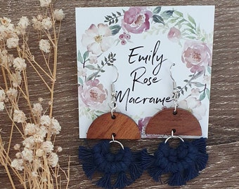 May include: A pair of navy blue macrame earrings with wooden half-circle pendants. The earrings are on a card with the text "Emily Rose Macrame".