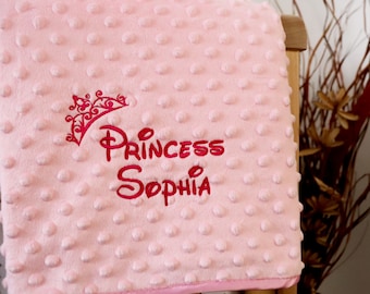 May include: Pink baby blanket with a red embroidered crown and the text "Princess Sophia".