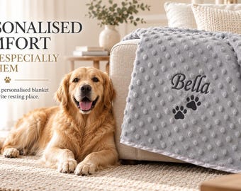 May include: A light gray textured dimpled blanket featuring the embroidered name Bella and two black paw prints. The text on the image reads: PERSONALISED COMFORT MADE ESPECIALLY FOR THEM. A soft and cosy personalised blanket for their favourite resting place.
