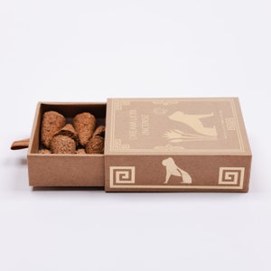May include: A brown cardboard box with a sliding drawer containing brown incense cones. The box has a cream-colored illustration of a lion and the text "Dream Lion Incense".