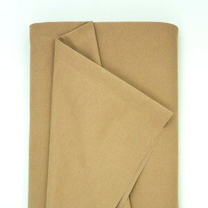 Peut inclure: Un morceau de tissu brun plié. Le tissu est lisse et a un léger brillant.