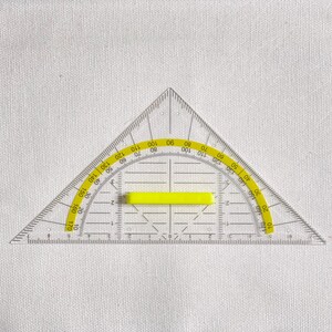 May include: A clear plastic protractor with a yellow accent. The protractor is triangular with degree markings from 0 to 180. It has a yellow rectangular bar in the center and is designed for measuring angles.