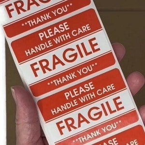 May include: A sheet of red and white fragile stickers. Each sticker has the text 