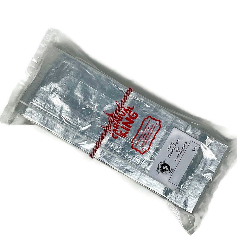 May include: A package of silver foil sheets for hobby, sewing, and party craft supplies. The package is tied with red string and has a red label with the text "Carnival King" and a circus tent graphic. The label also says "Hobby Sewing, Party and Craft Supplies 25ct".