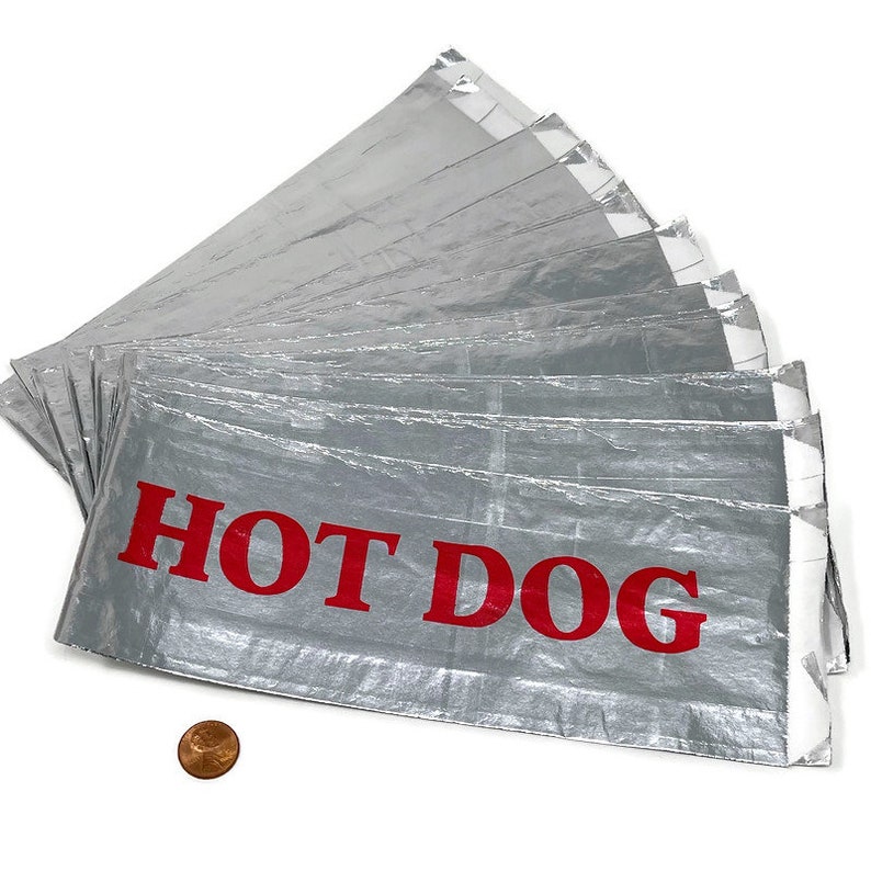 May include: A stack of ten silver foil hot dog wrappers with red lettering that says "HOT DOG".