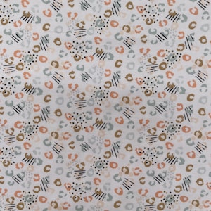 May include: A white fabric with a repeating pattern of brown, peach, and blue abstract shapes. The shapes are reminiscent of animal print.