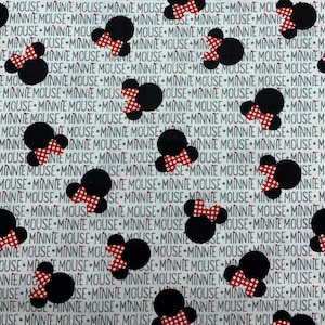325 COTTON fabric white with words Minnie Mouse and tossed black Minnie Mouse balloons with red and white dots bows sold by the yard.