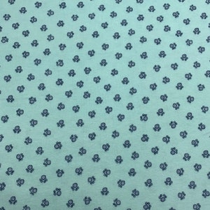 May include: A light blue fabric with a repeating pattern of small black paw prints.