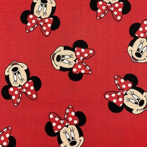 521 COTTON fabric red background with tossed Minnie Mouse faces sold by the yard.