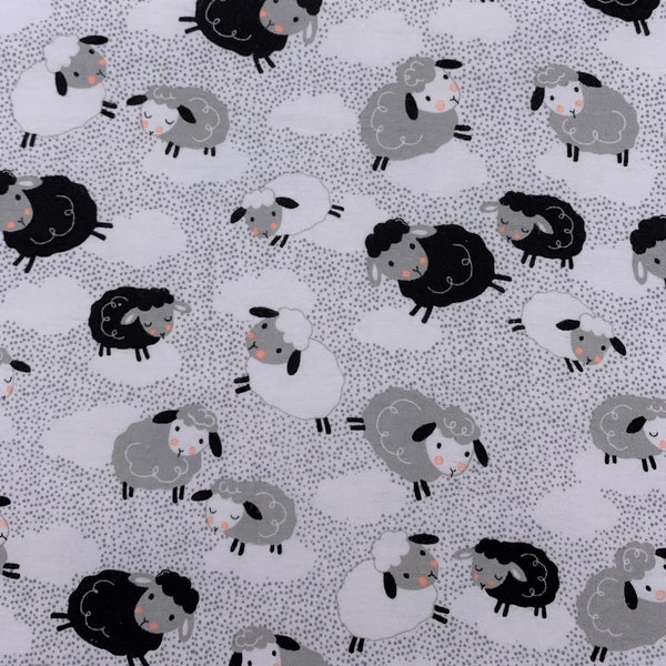 895 Flannel fabric white background with little gray specks and white gray black tossed sheep & clouds sold by the yard.