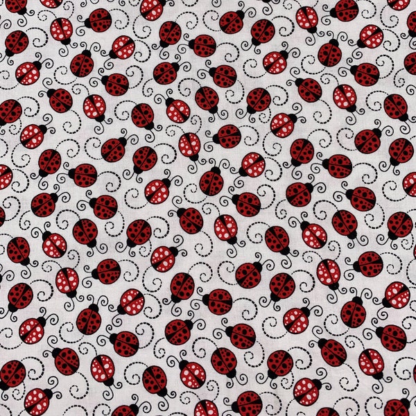 477 COTTON fabric white background with tossed red & black ladybugs and black swirls sold by the yard.