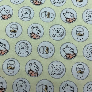 324 COTTON fabric light yellow background with Winnie the Pooh honey pots with bees framed in circles sold by the yard.