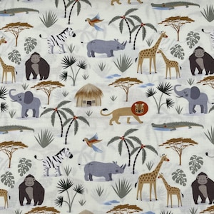 688 COTTON fabric cream background with safari animals huts palm trees sold by the yard.