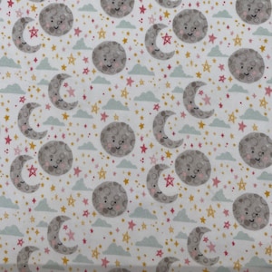 980 Flannel fabric white background with pink & gold stars blue clouds gray moons with faces sold by the yard.
