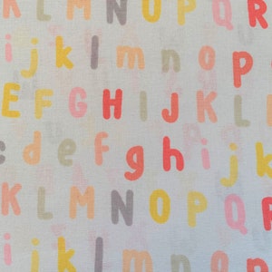 333 COTTON fabric white background with pastel alphabet letters sold by the yard.