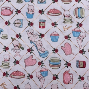 May include: White fabric with a repeating pattern of cherubs, cupcakes, and kitchen items. The pattern is in a diamond shape and includes the words "Kewpie" and "Jam".