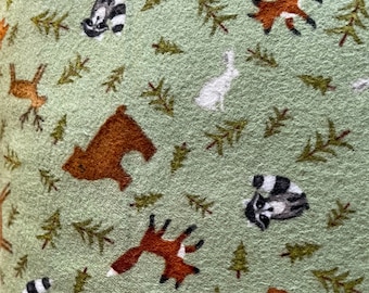 1204 Flannel fabric green background with tossed forest animals & forest trees sold by the yard.