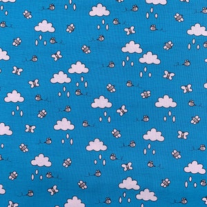 May include: A blue fabric with a white cloud and bee pattern. The clouds have raindrops falling from them.