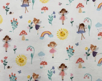 1361 Flannel fabric white with pixies, rainbows, suns mushrooms & flowers sold by the yard.