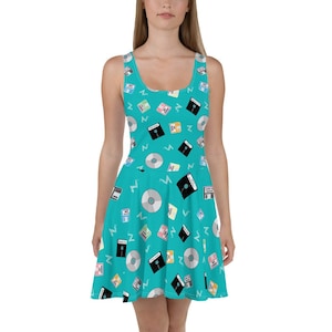 Puede incluir: Un vestido skater turquesa con un patrón de disquetes coloridos y discos compactos plateados. El vestido tiene un escote redondo y es sin mangas.